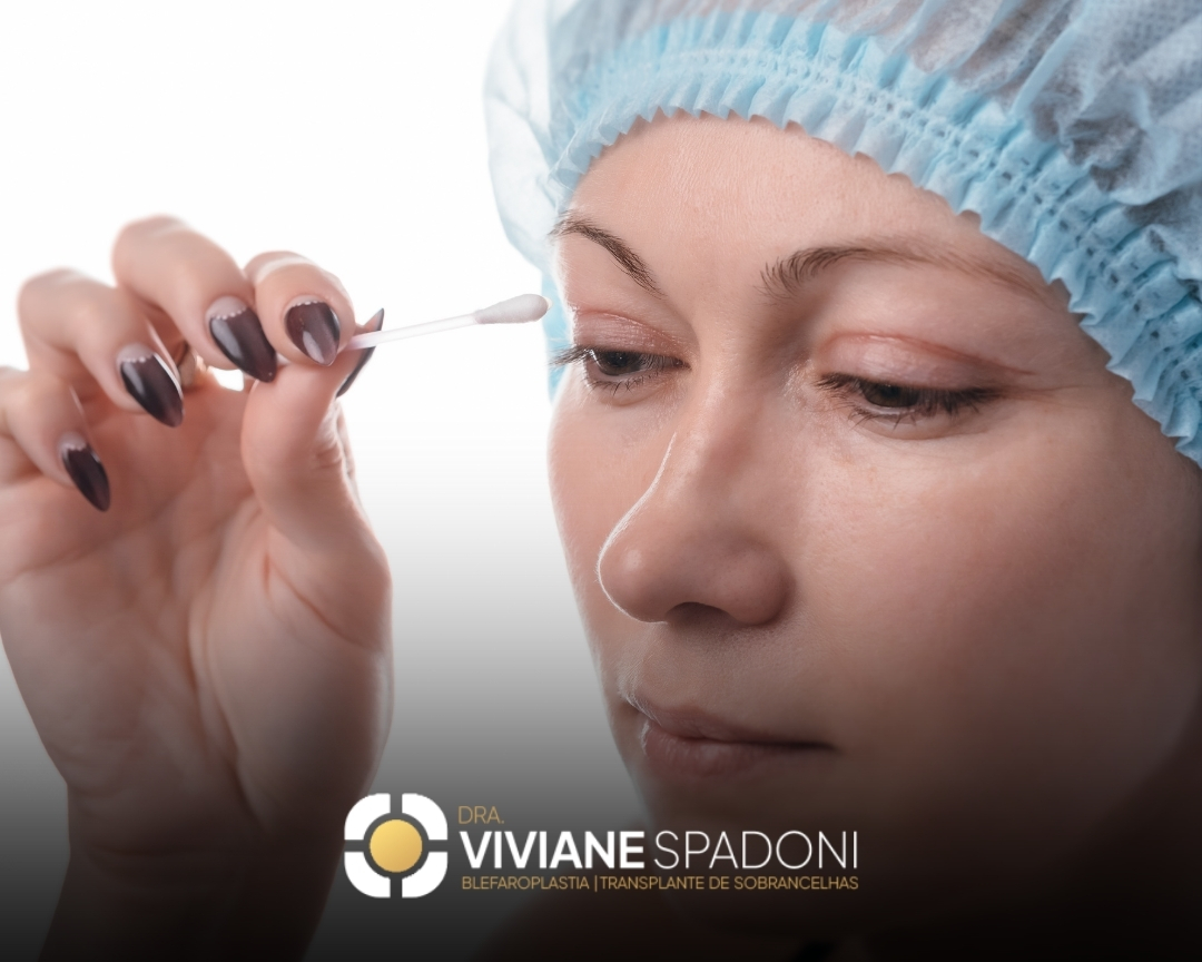 Mulher usando touca cirúrgica faz higienização na região dos olhos com hastes flexíveis, preparando-se para procedimento de blefaroplastia. Na parte inferior da imagem, está o logo da Dra. Viviane Spadoni com a legenda "Blefaroplastia | Transplante de Sobrancelhas".